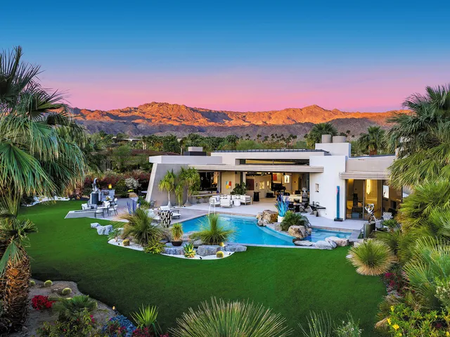 a view of a swimming pool with a table and chairs under an umbrella