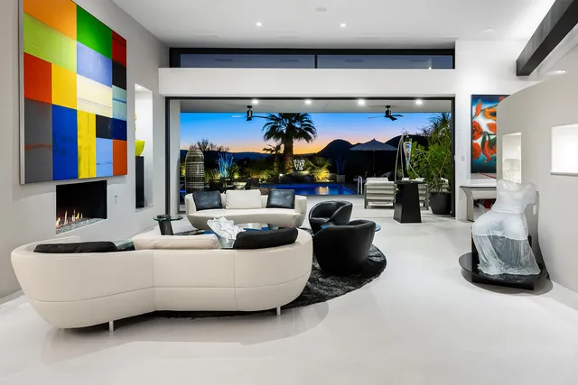 a living room with patio furniture and a potted plant