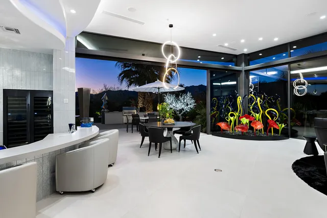 a living room with furniture a flat screen tv and a floor to ceiling window