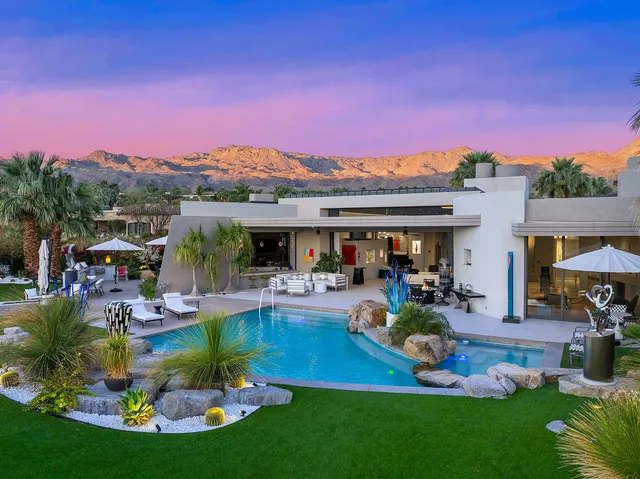 a front view of a house with a yard and potted plants