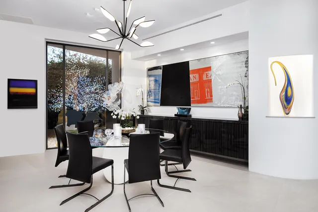 a living room with furniture a floor to ceiling window and potted plant