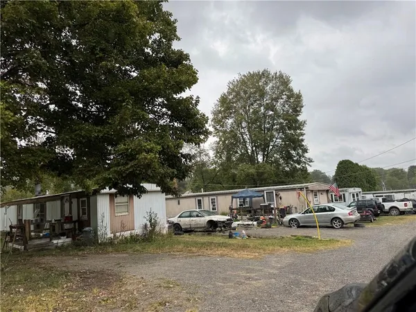 a view of swimming pool with lawn chairs and plants