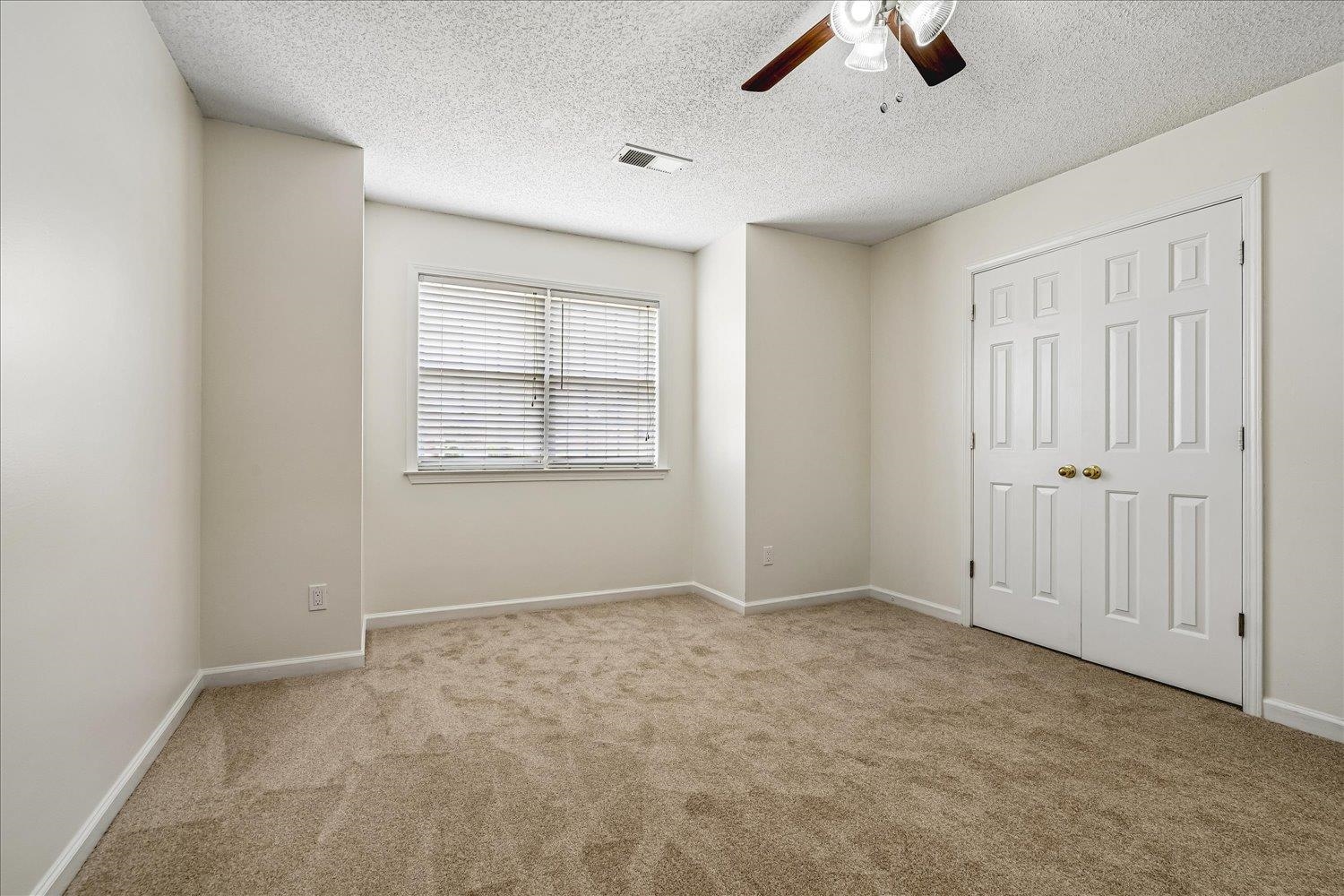 6335 Needle Ridge Road Bartlett, TN 38135 - Photo 21 of 25 Carpeted room featuring a window with blinds, a ceiling fan, and bi-fold closet doors