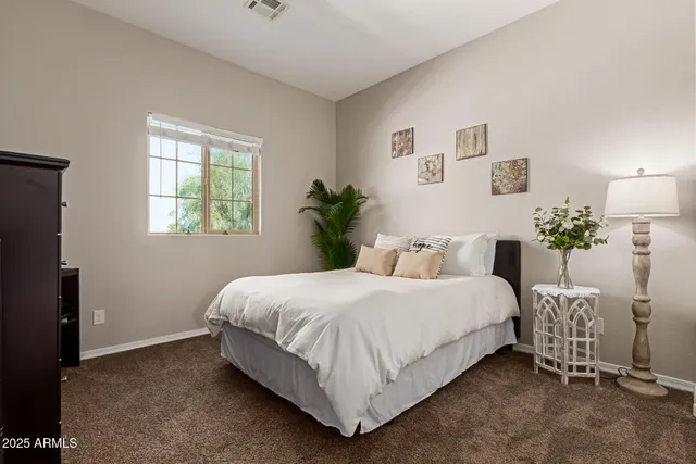 a bedroom with a bed and a potted plant