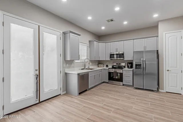 a kitchen with a refrigerator and a stove top oven