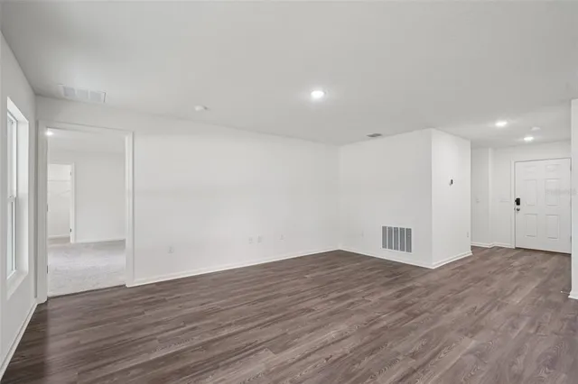 a view of empty room with wooden floor