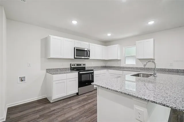a kitchen with granite countertop white cabinets and white appliances