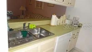 a bed sitting in a bedroom next to a window with cabinet