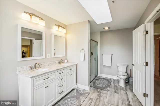 a bathroom with a granite countertop sink toilet and shower