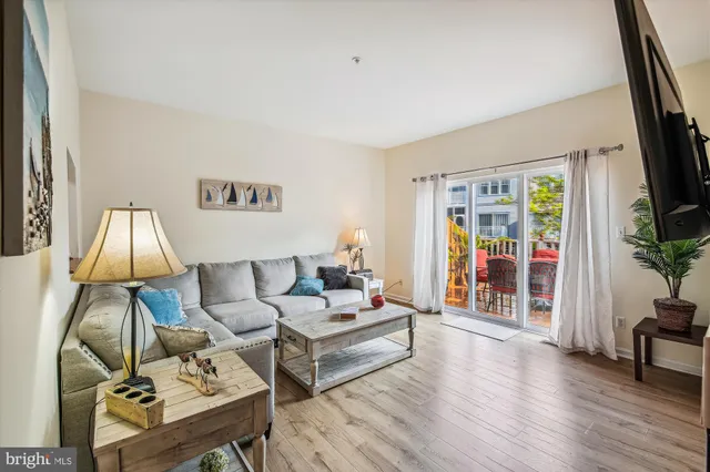 a living room with furniture a wooden floor and a flat screen tv