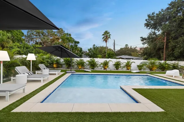 a view of swimming pool with outdoor seating and plants