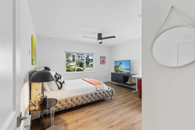 a bedroom with a bed and wooden floor