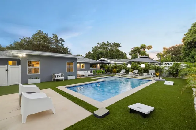 a view of a house with swimming pool and furniture