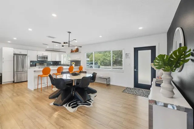 a dining room with furniture a chandelier and wooden floor