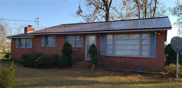 a view of house with roof and outdoor space