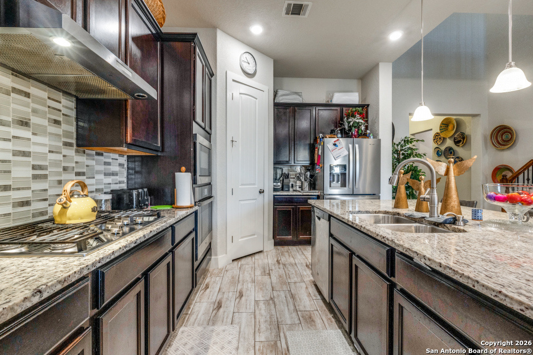 1712 Delafield Road San Antonio, TX 78253 - Photo 8 of 25 a kitchen with stainless steel appliances granite countertop a refrigerator a stove and a sink