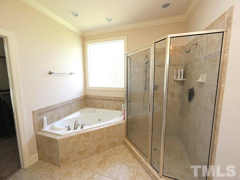 4740 Sandy Bay Circle Raleigh, NC 27603 - Photo 13 of 24 a bathroom with a bathtub and a shower