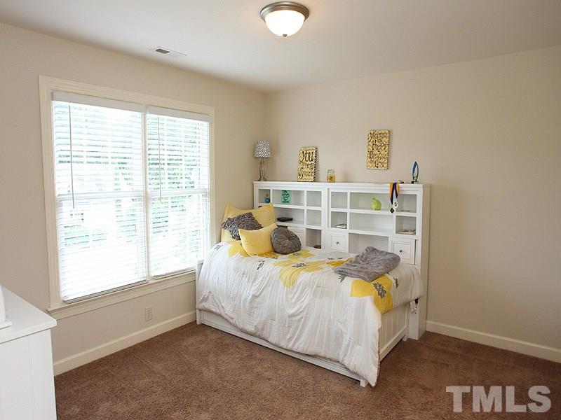 4740 Sandy Bay Circle Raleigh, NC 27603 - Photo 16 of 24 a bed sitting in a bedroom next to a window