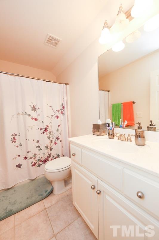 4740 Sandy Bay Circle Raleigh, NC 27603 - Photo 17 of 24 a bathroom with a sink a toilet and shower curtain