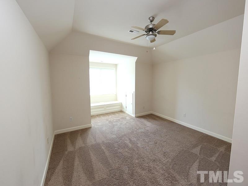 4740 Sandy Bay Circle Raleigh, NC 27603 - Photo 19 of 24 an empty room with a ceiling fan and a window