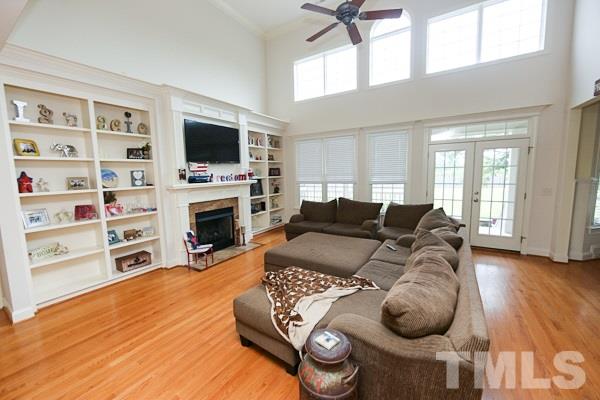4740 Sandy Bay Circle Raleigh, NC 27603 - Photo 3 of 24 a living room with furniture a flat screen tv and a fireplace