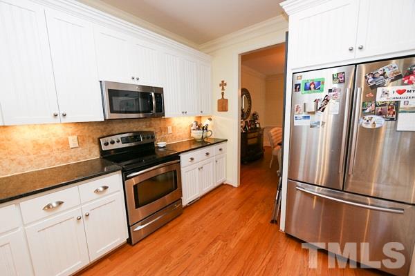 4740 Sandy Bay Circle Raleigh, NC 27603 - Photo 8 of 24 a kitchen with stainless steel appliances a refrigerator sink and microwave