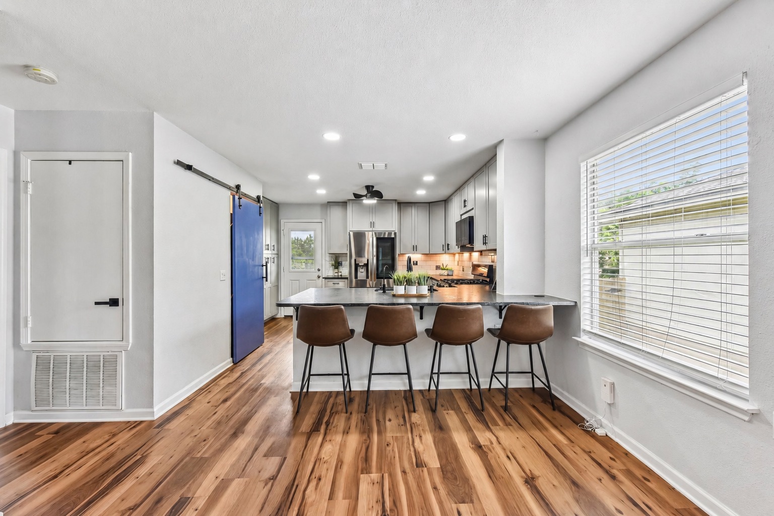 5405 Rusk Court Austin, TX 78723 - Photo 6 of 40 Beautiful laminate wood floors welcome you into this inviting kitchen featuring a practical island with seating.