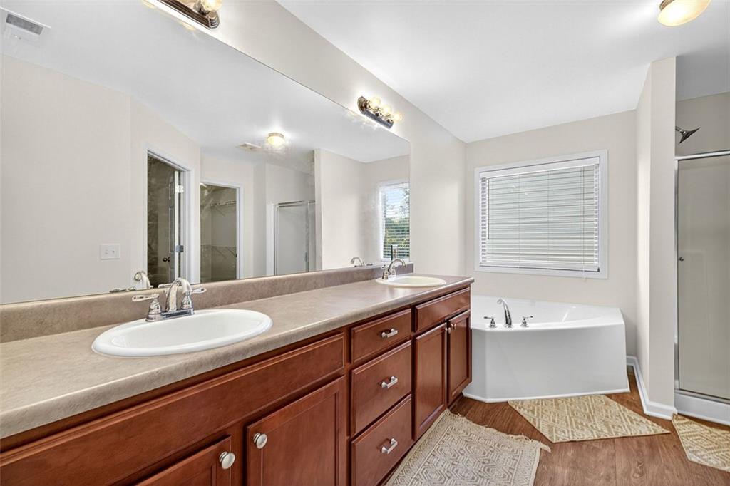 2517 Kolb Manor Circle Southwest Marietta, GA 30008 - Photo 18 of 33 a bathroom with a granite countertop sink a large mirror and a bathtub