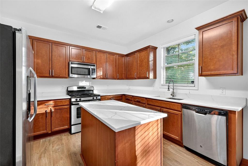 2517 Kolb Manor Circle Southwest Marietta, GA 30008 - Photo 8 of 33 a kitchen with stainless steel appliances granite countertop a stove a sink dishwasher a refrigerator and a microwave oven with wooden floor