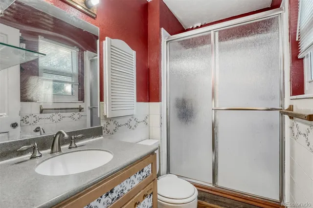 a bathroom with a granite countertop sink toilet and shower