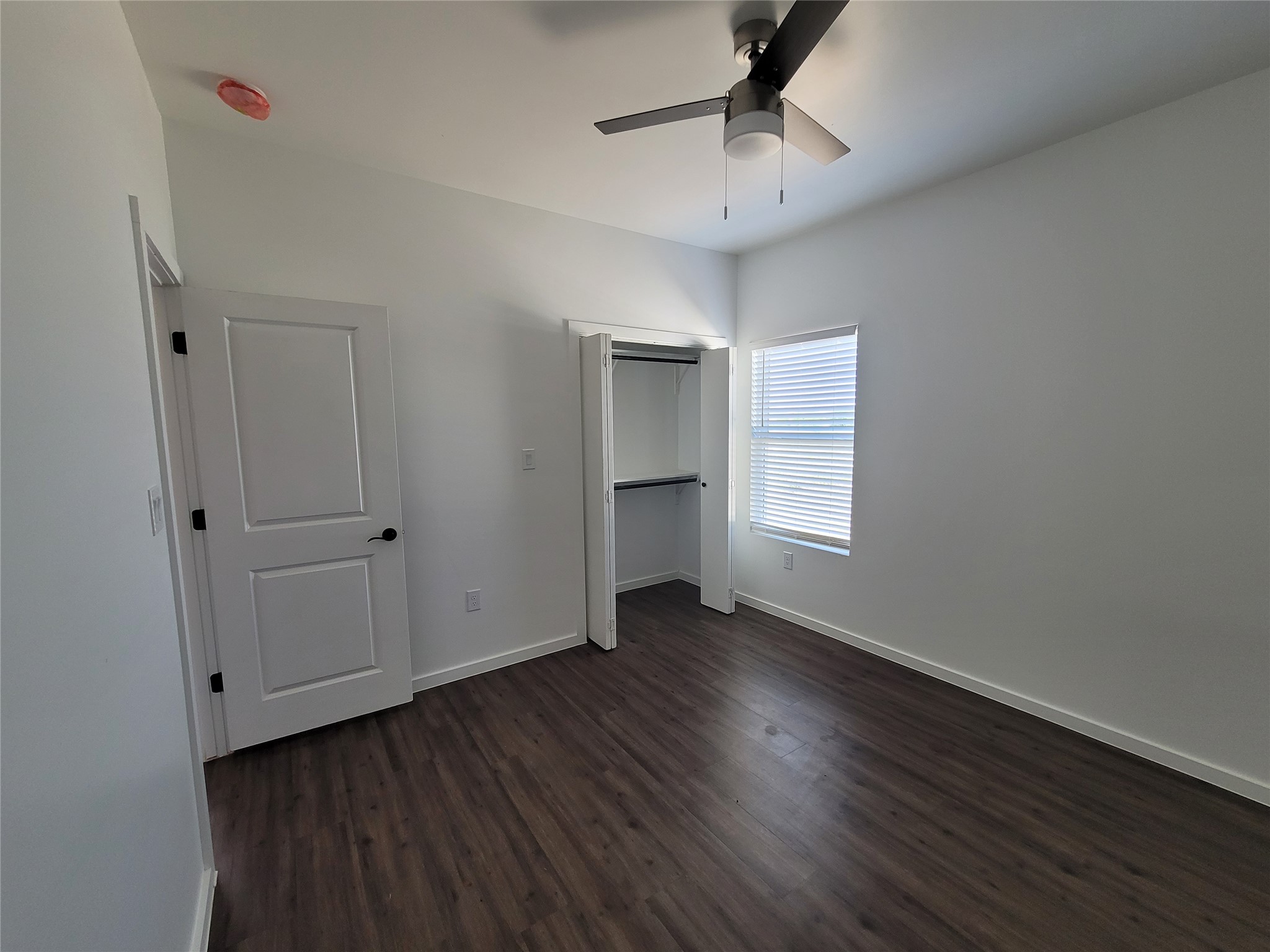 422 A Road Stockdale, TX 78160 - Photo 34 of 40 An inviting room awaits, featuring rich hardwood floors and a modern ceiling fan for comfort.