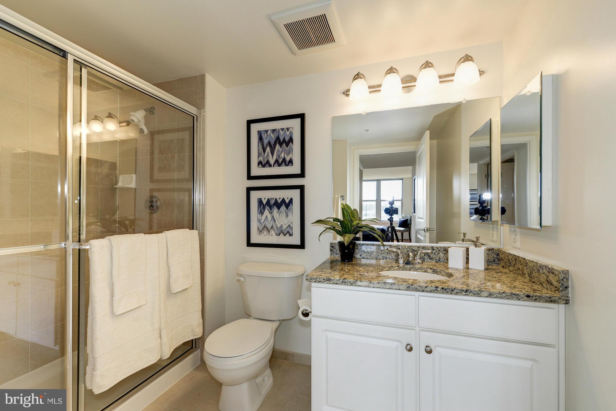 11800 Sunset Hills Road, Unit 517 Reston, VA 20190 - Photo 13 of 29 a bathroom with a granite countertop sink mirror toilet and shower