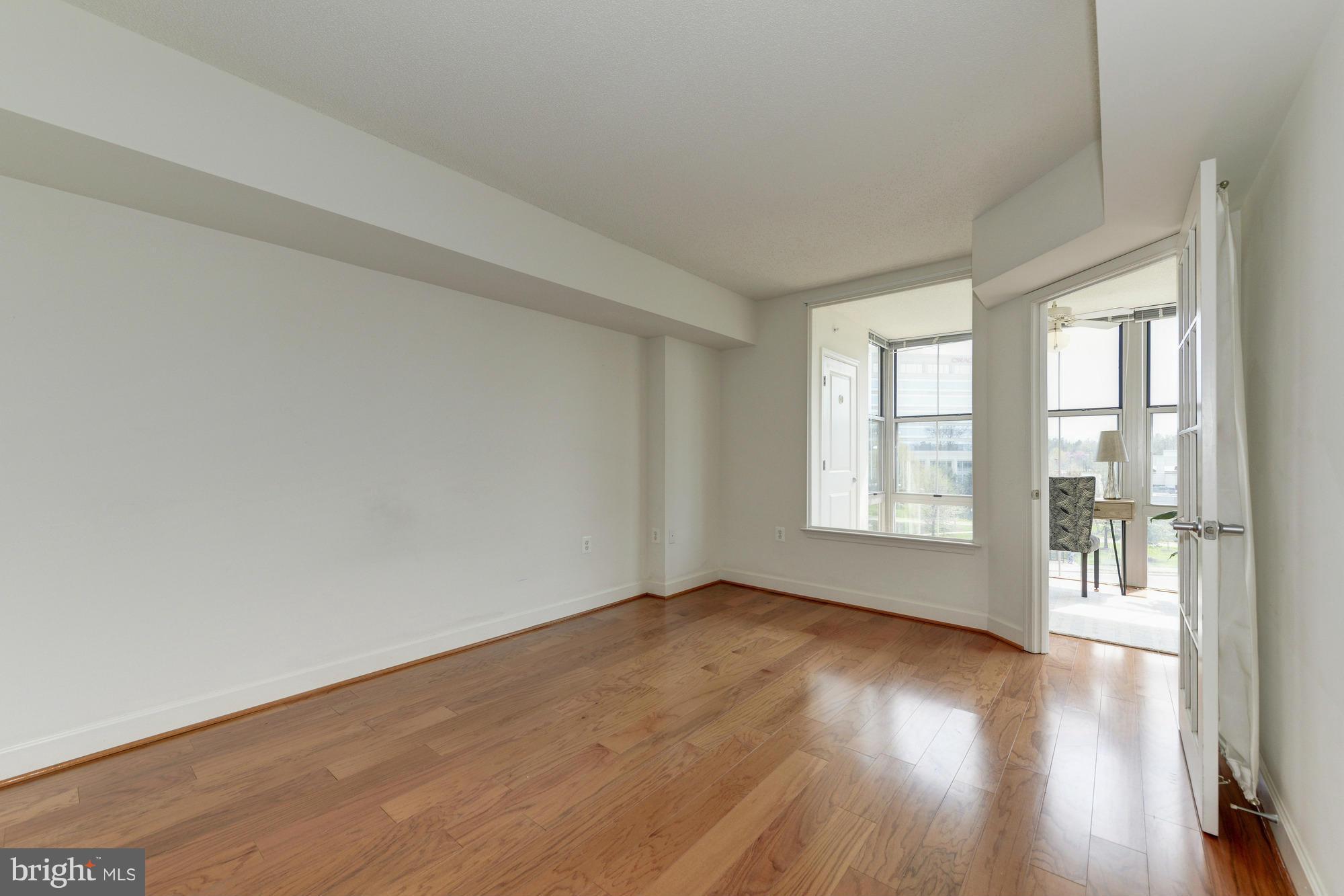 11800 Sunset Hills Road, Unit 517 Reston, VA 20190 - Photo 14 of 29 an empty room with wooden floor and windows