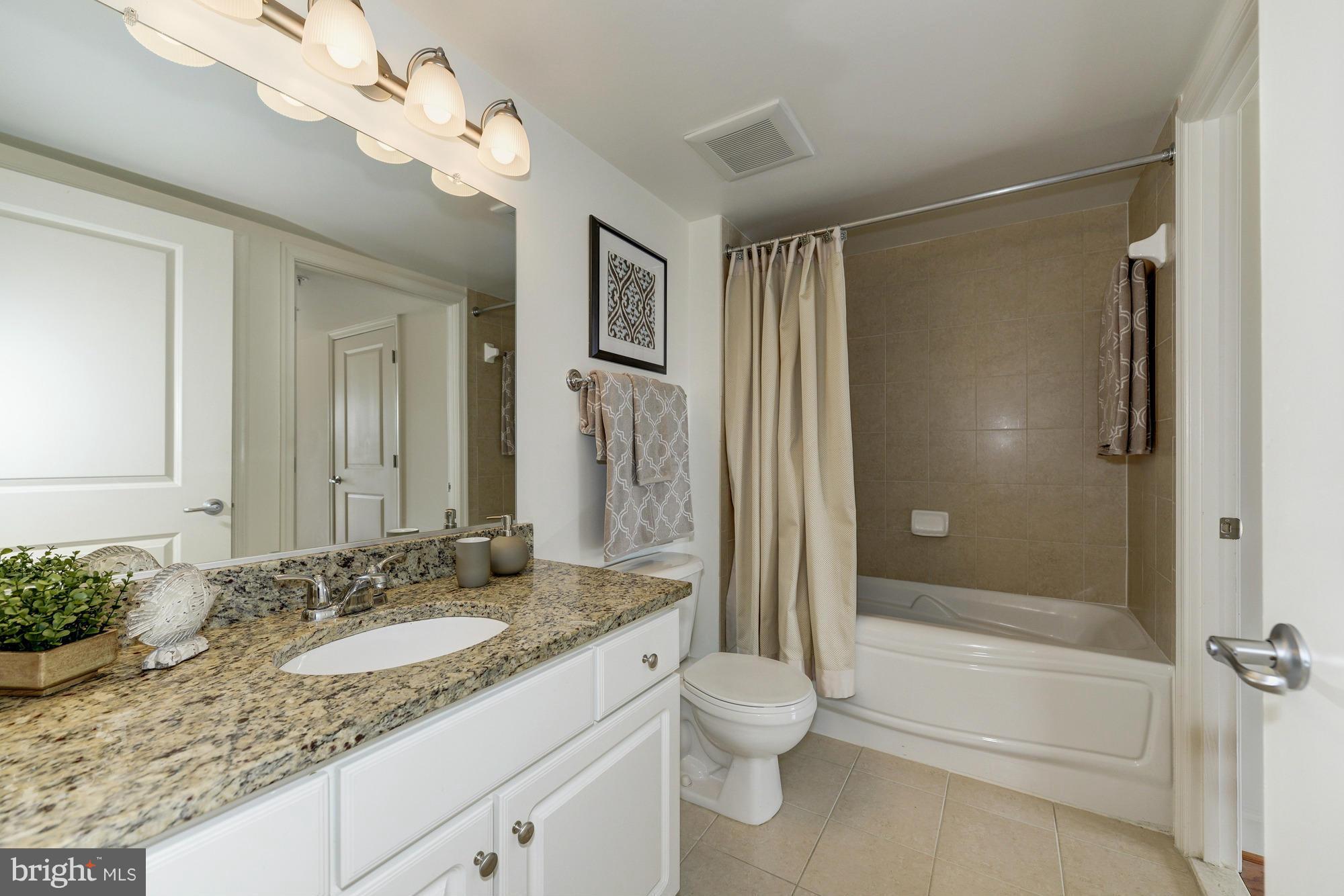 11800 Sunset Hills Road, Unit 517 Reston, VA 20190 - Photo 15 of 29 a bathroom with a granite countertop sink a toilet and shower