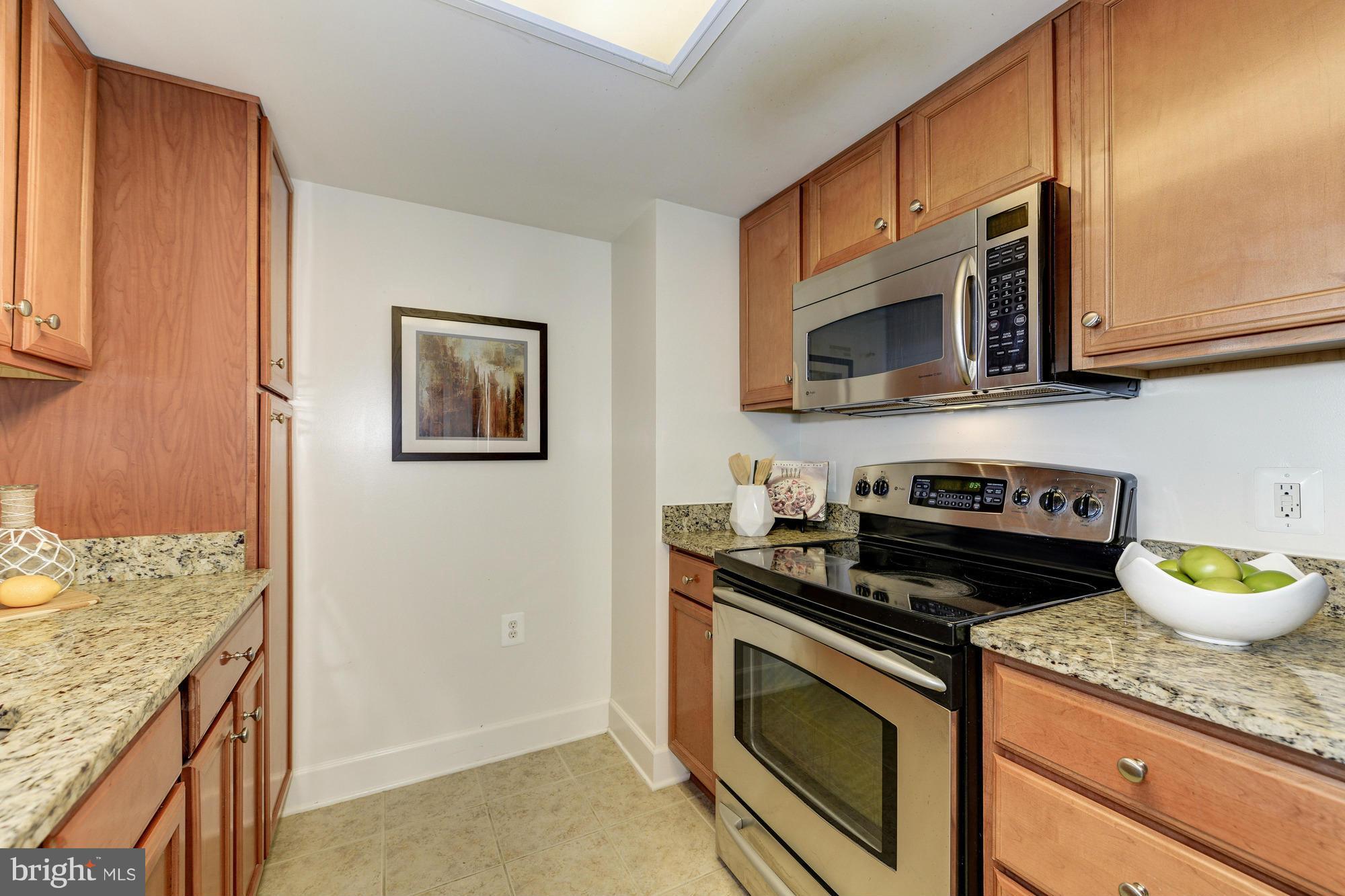 11800 Sunset Hills Road, Unit 517 Reston, VA 20190 - Photo 7 of 29 a kitchen with stainless steel appliances granite countertop a stove a microwave and cabinets