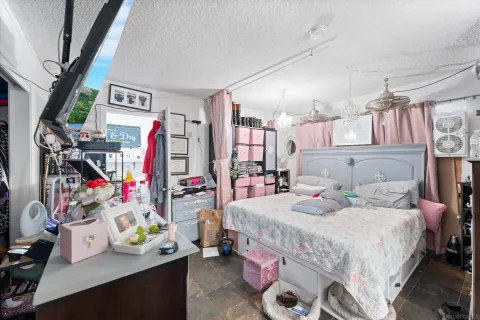 a bedroom with a bed a books and a window