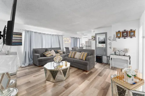 a living room with furniture a flat screen tv and kitchen view