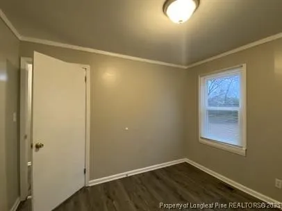 a view of an empty room with window and closet area