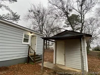 a view of a house with a yard and large tree