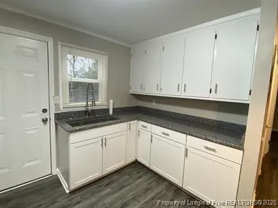 a kitchen with granite countertop white cabinets and sink