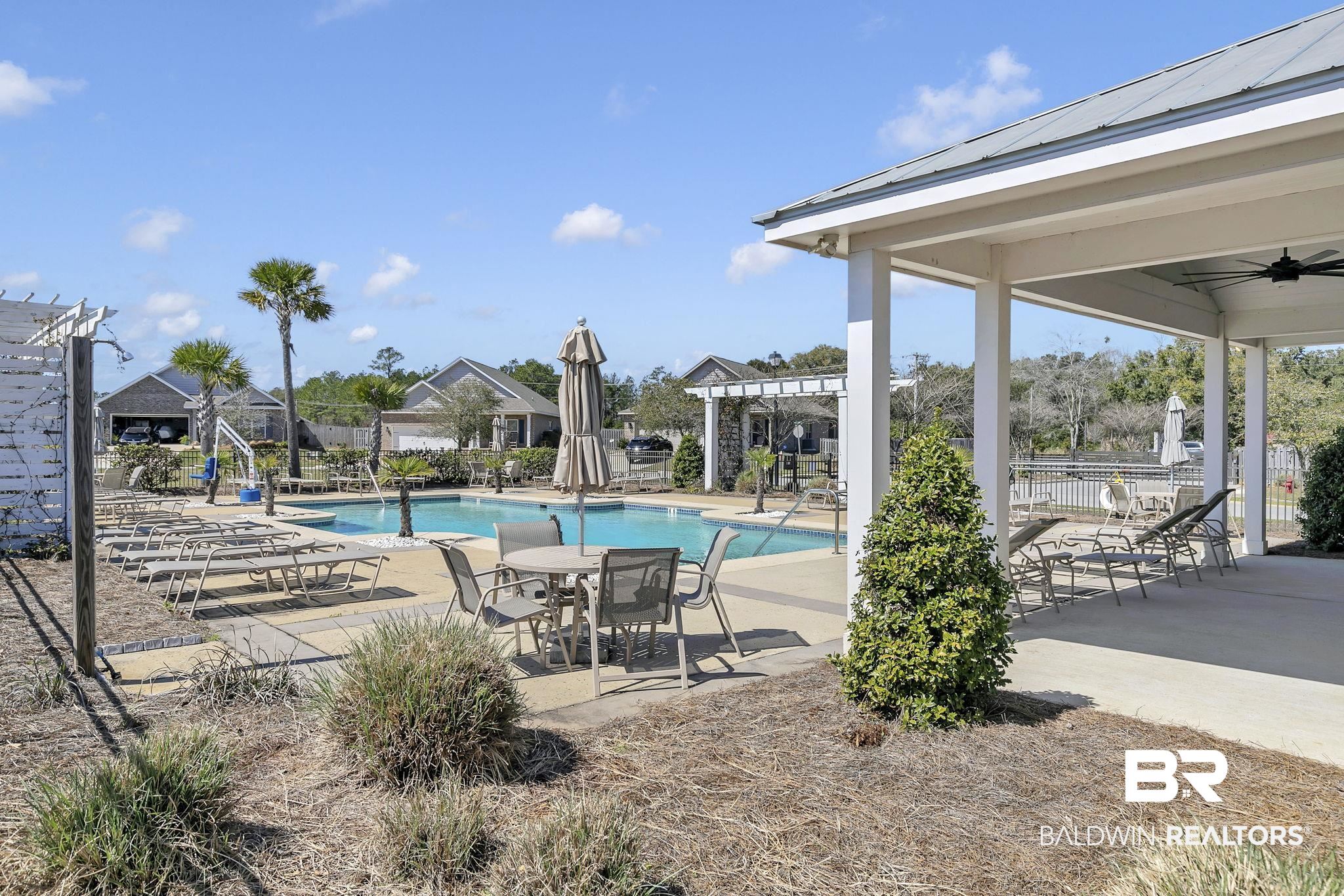 1547 Kairos Loop Foley, AL 36535 - Photo 46 of 55 Community pool featuring a ceiling fan, a patio, fence, and a pergola
