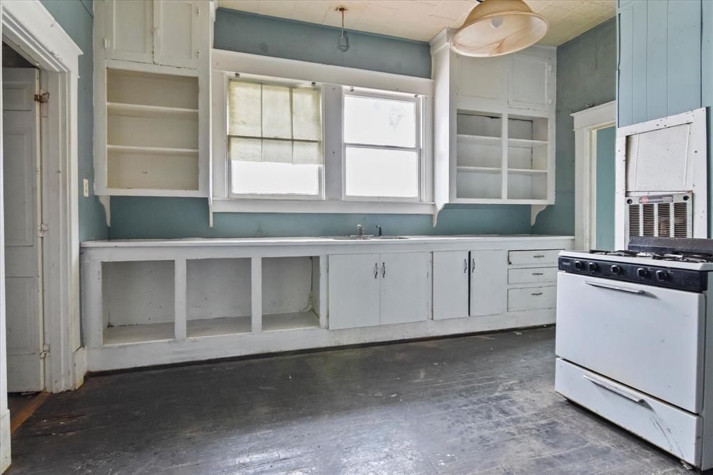738 1st Street Southwest Paris, TX 75460 - Photo 9 of 25 Kitchen with white gas range, white cabinetry, and open shelves