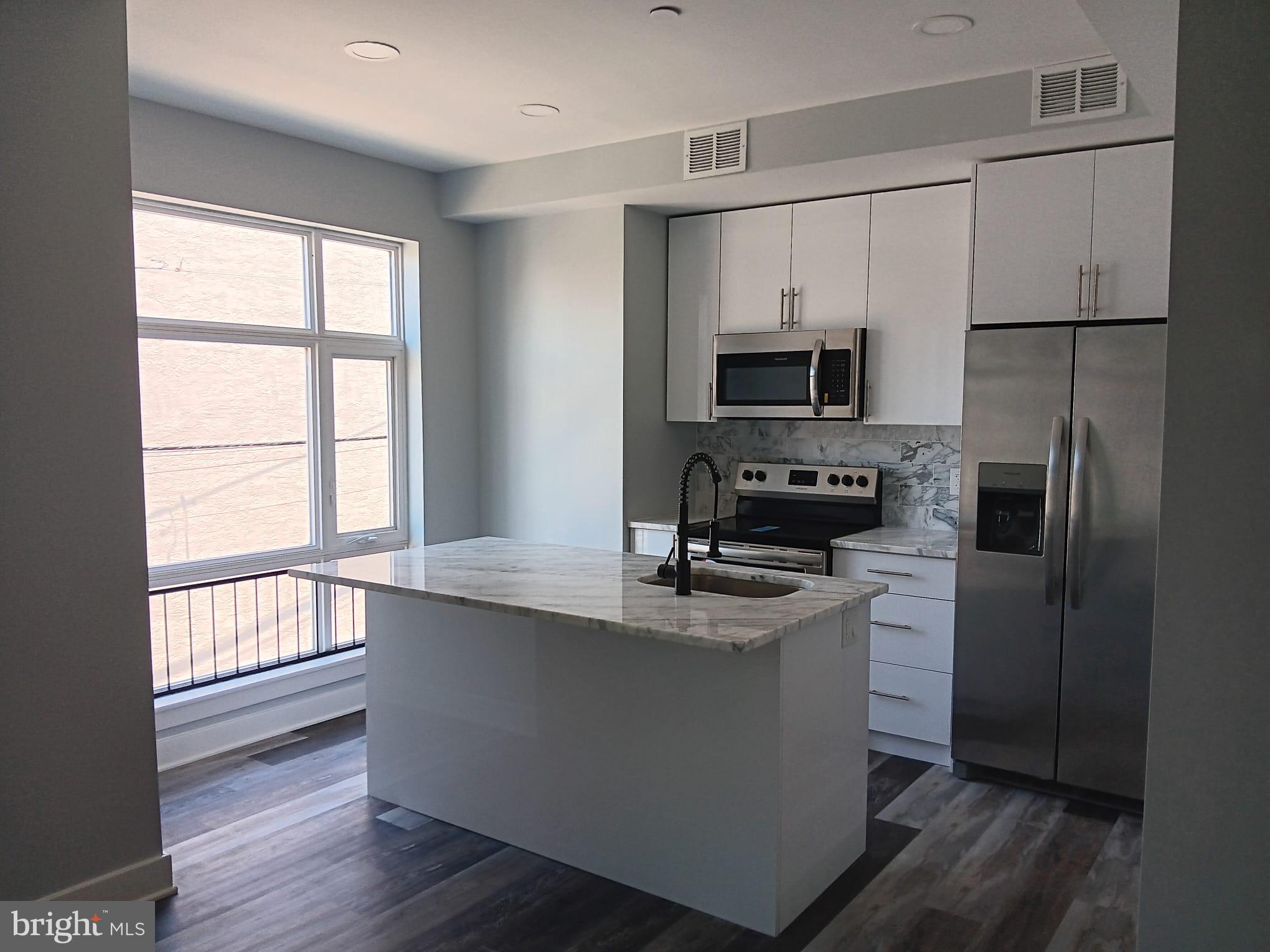 a kitchen with a refrigerator and a stove