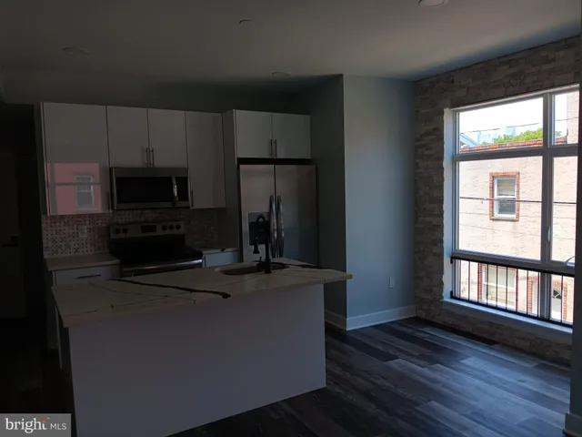 a kitchen with kitchen island a stove a sink and a microwave