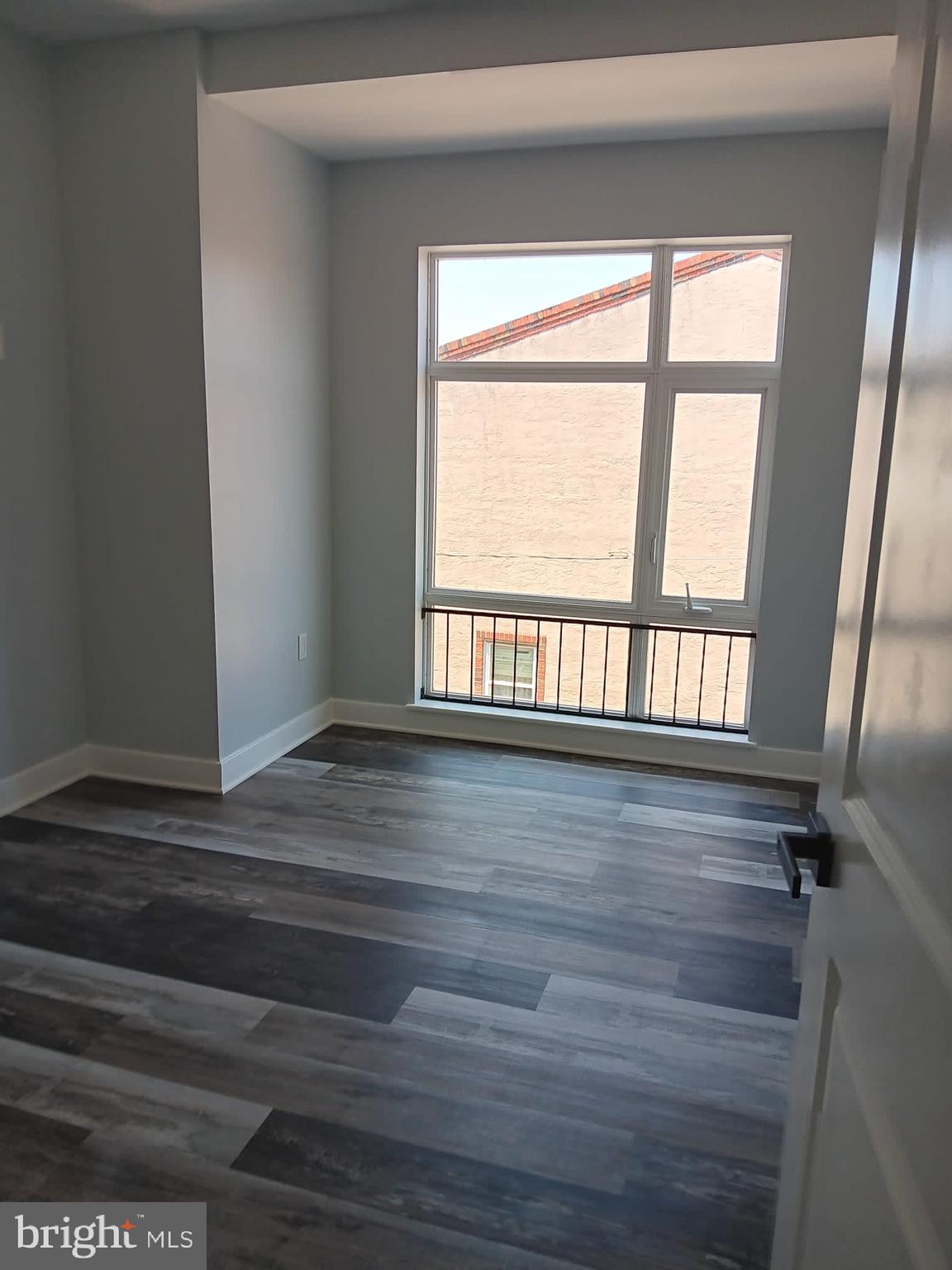 1328 South 6th Street, Unit 2 Philadelphia, PA 19147 - Photo 4 of 7 a view of an empty room with wooden floor and a window