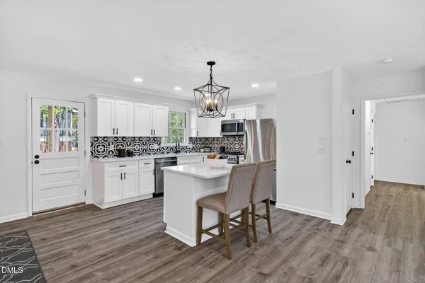a kitchen with stainless steel appliances granite countertop a stove refrigerator and white cabinets