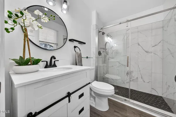 a bathroom with a sink a toilet and shower