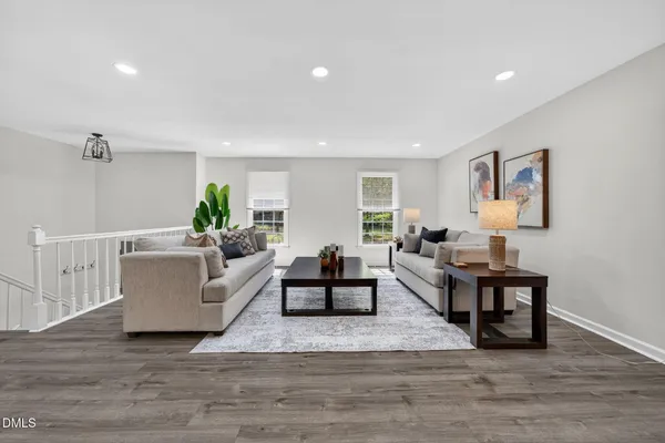 a living room with furniture a dining table and a wooden floor