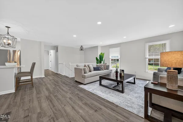 a living room with furniture kitchen view and a potted plant