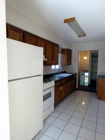 304 Ralph Court Island Lake, IL 60042 - Photo 5 of 16 a kitchen with granite countertop a refrigerator and a stove top oven